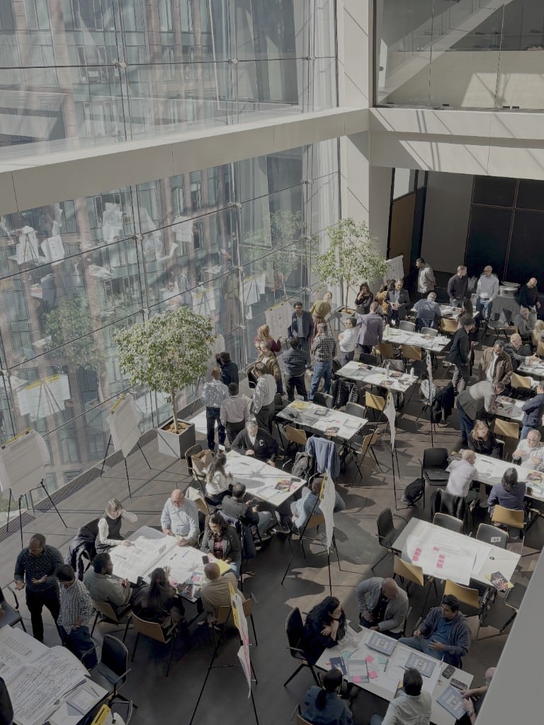 Teams working through ideas at tables during one of Sally’s innovation workshops